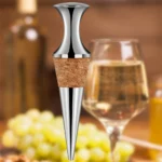 Weinkorken neben einem Glas Weißwein und Trauben