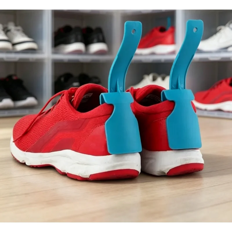 Blaue Schuhformer in roten Sneakern auf einem Holzboden vor einem Schuhregal