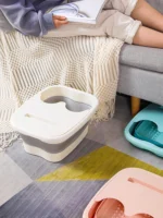 Faltbare Fußbadewannen in Weiß, Blau und Rosa neben einem Sofa