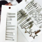 Set mit 24 silbernen Metall-Haarspangen inklusive Sternspangen auf Präsentationskarten