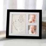 Rahmen für Baby-Hand- und Fußabdruck (Version mit schwarzem Rahmen) auf einem Tisch am Fenster