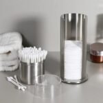 Wattestäbchenhalter mit Stäbchen und Pads im Badezimmer