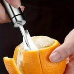 Schälen einer Orange mit einem Zitrusschäler